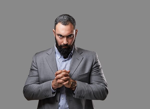 Studio portrait of serious, bearded male dressed in a suit.