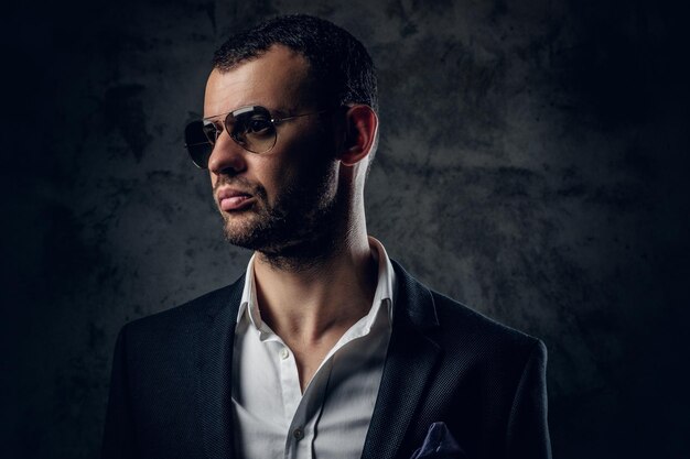 Studio portrait of serious modern male in white shirt and business jacket on grey background.