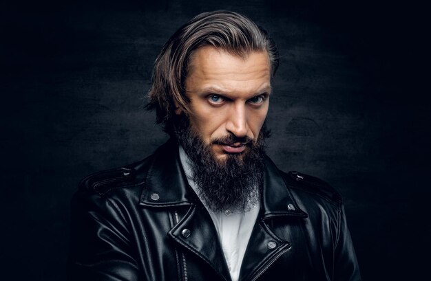 Studio portrait of stylish bearded male in black leather jacket.