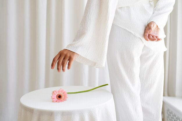 Free photo studio portrait with woman and pink flower