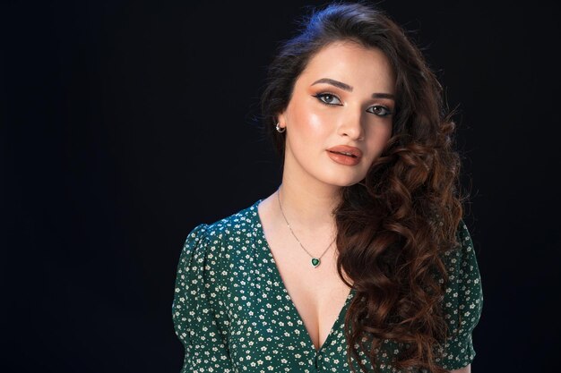 Studio portrait of a young beautiful brunette woman against black background