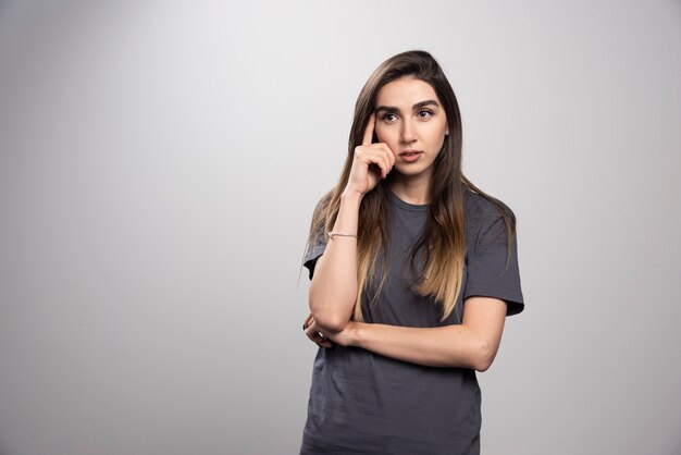 Studio portrait of young woman thinking and looking away .