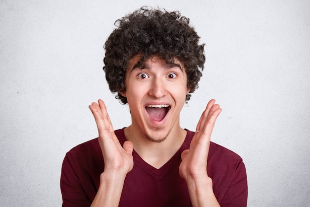 Foto gratuita lo studio ha sparato dell'uomo attraente con capelli ricci scuri