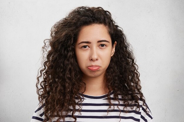 Studio shot of beautiful female model with grumpy expression being offended