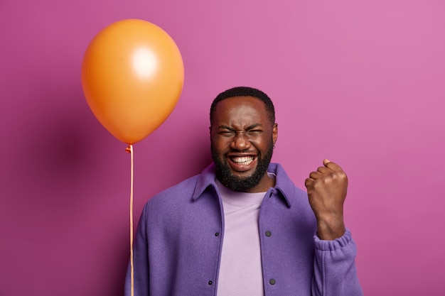 Free photo studio shot of energetic man celebrates memorable event in life, becomes father first, going to congratulate wife, clenches fist with happiness