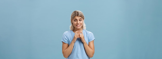 Free photo studio shot of insecure and timid silly girlfriend with blond hair clenching teeth looking shy down