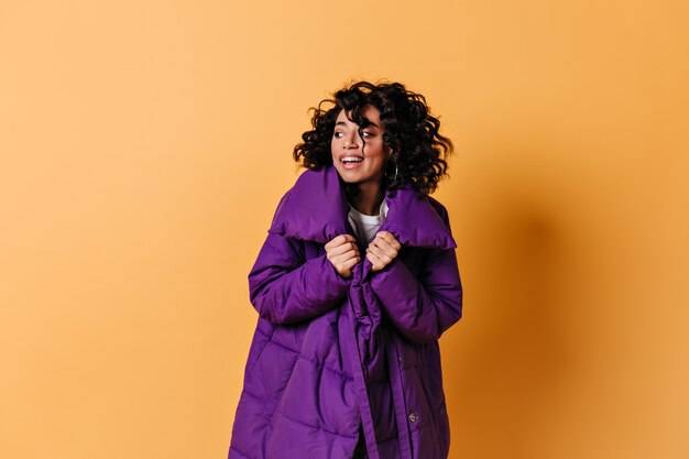 Бесплатное фото Студийный снимок молодой женщины в фиолетовом пуховике