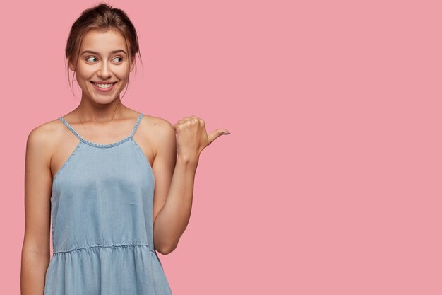 Studio shot of pleased European woman with joyful expression