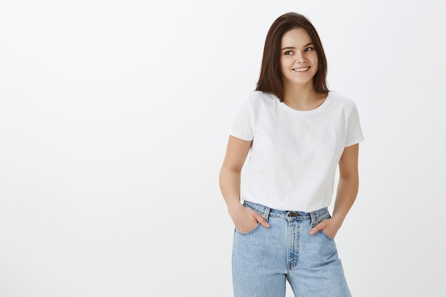 Free photo studio shot of stylish young woman posing against white wall