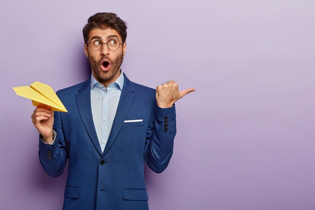 Studio shot of surprised businessman posing in classy suit at the office