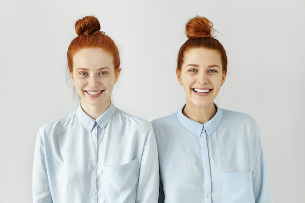 Студийный снимок двух кавказских братьев и сестер с одинаковыми пучками рыжих волос