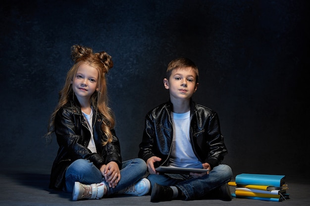 두 아이의 스튜디오 샷 태블릿 바닥에 앉아