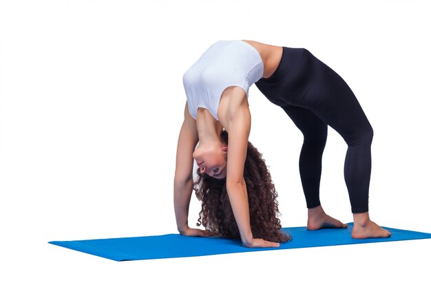 Studio shot of a young fit woman doing yoga exercises.
