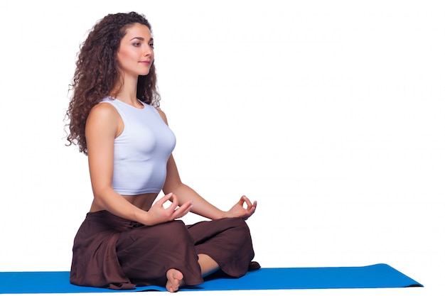 Free photo studio shot of a young woman doing yoga exercises on white background