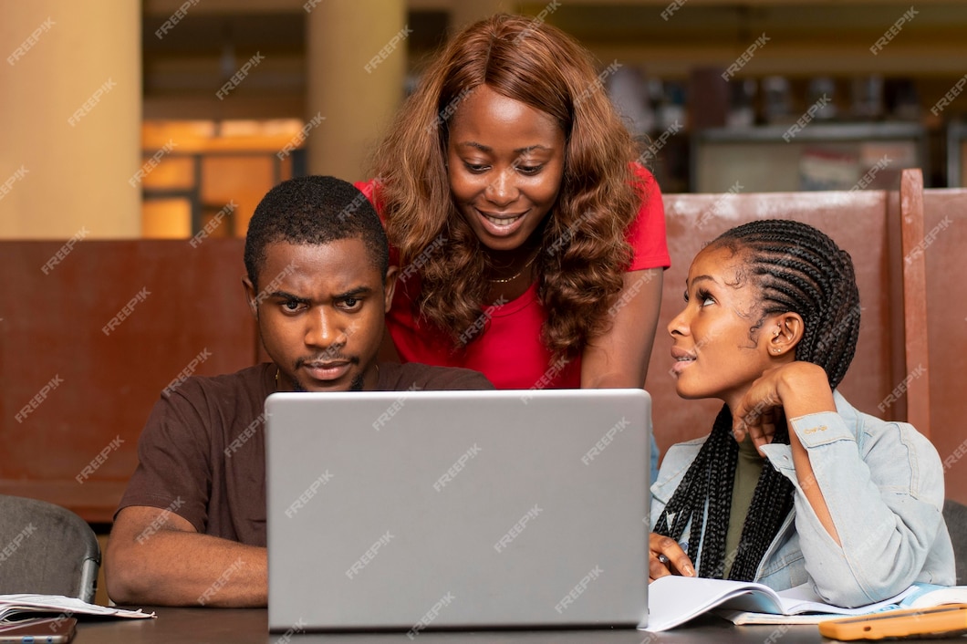 three young black students looking at a laptop screen