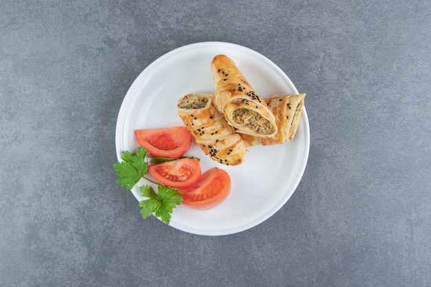 Stuffed pastries with meat on white plate.