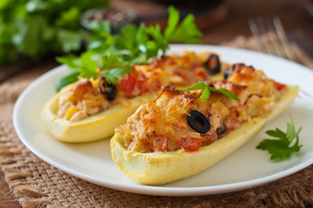 Stuffed zucchini with chicken, tomatoes and olives with cheese crust