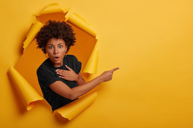 Stunned Afro American woman looks with scared speechless expression