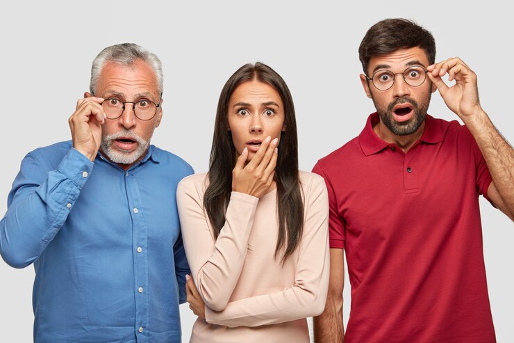 Free Photo stunned brother, sister and their elderly father posing against the white wall