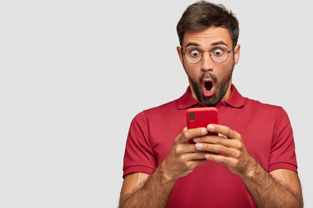 stunned young emotional man posing against the white wall