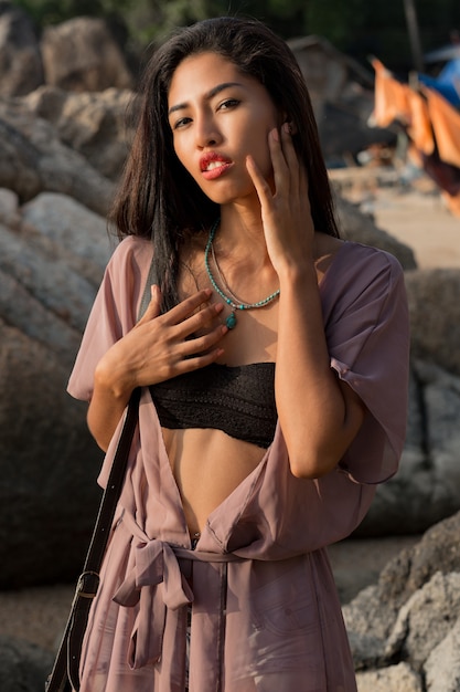 Free photo stunning asian woman in summer outfit posing on the brach.