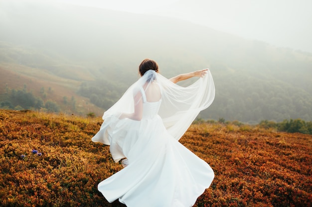 Stunning bride whirls on the yellow grass