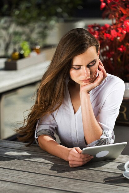 Stunning brunette reads something on her tablet