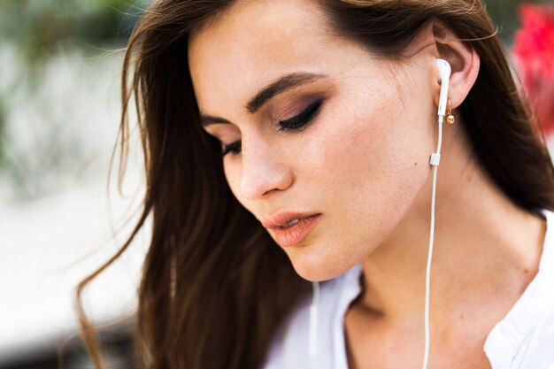 Stunning brunette with headphones in her ears