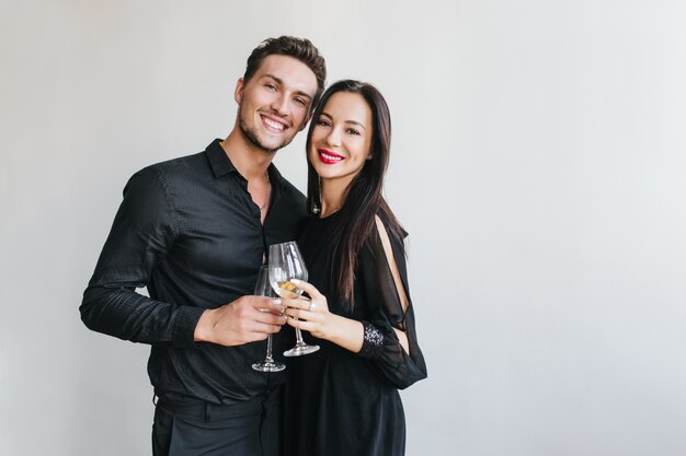 Stunning brunette woman clink glasses with handsome husband during friend's party