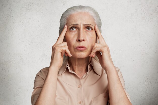 Stunning elderly woman against concrete wall