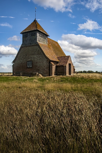 Потрясающий снимок старой церкви и травянистого поля в Великобритании в пасмурный день