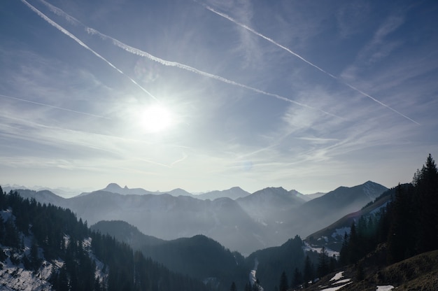 Stunning shot of a range of beautiful mountains under a bright sky in the early morning