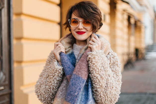 Splendida donna con sciarpa in posa sulla strada