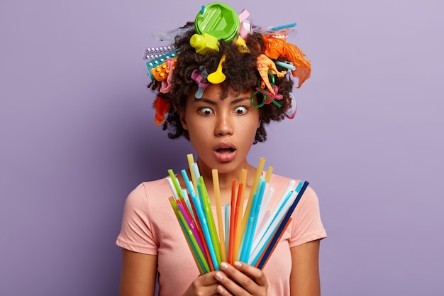 Foto gratuita donna stupefatta che posa con la spazzatura tra i capelli