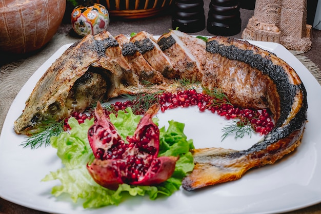 Sturgeon lavangi with walnuts cheery plum onion pomegranate lettuce side view