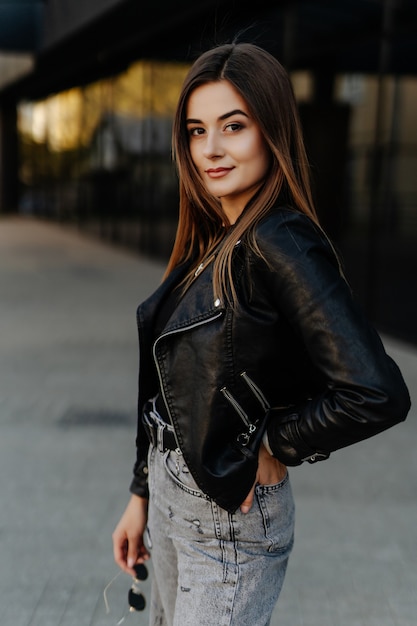 Style portrait of young trendy girl walking along the street