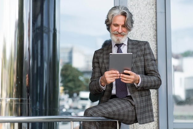 Stylish adult male holding tablet