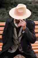 Free photo stylish adult male with hat posing outdoors