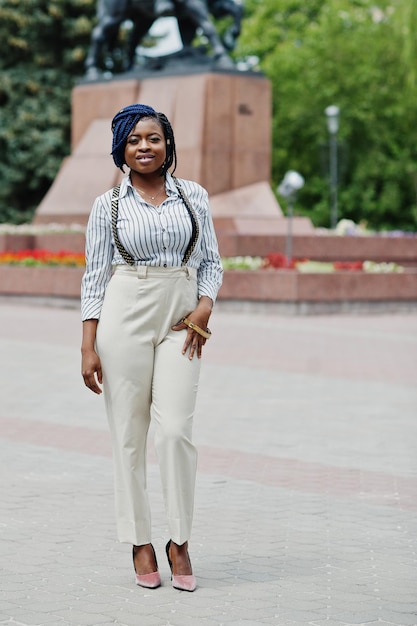 Stylish african american business woman at trousers with suspender and blouse posed outdoor