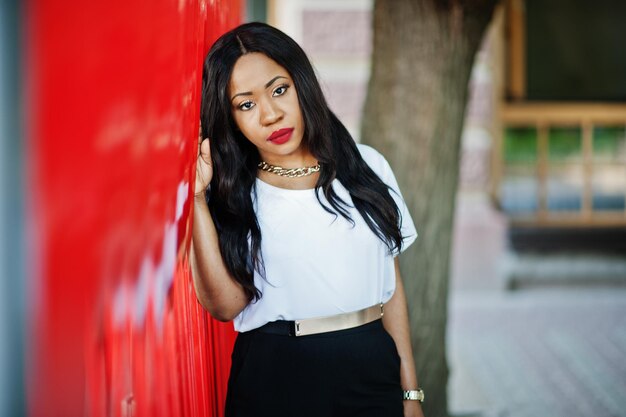 Stylish african american business woman with handbag on streets of city