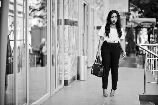 도시의 거리에 핸드백을 들고 세련된 아프리카계 미국인 비즈니스 여성