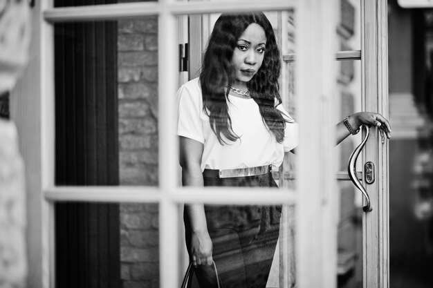 Stylish african american business woman with handbag on streets of city