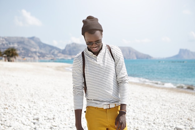 Foto gratuita elegante uomo afro-americano sulla spiaggia