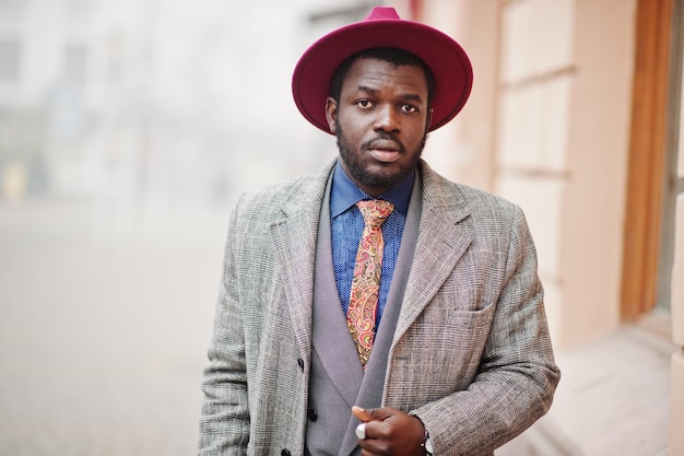 회색 코트 재킷 넥타이와 빨간 모자에 세련된 아프리카계 미국인 남자 모델