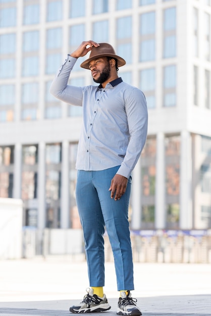 Foto gratuita elegante uomo afroamericano in posa con un cappello