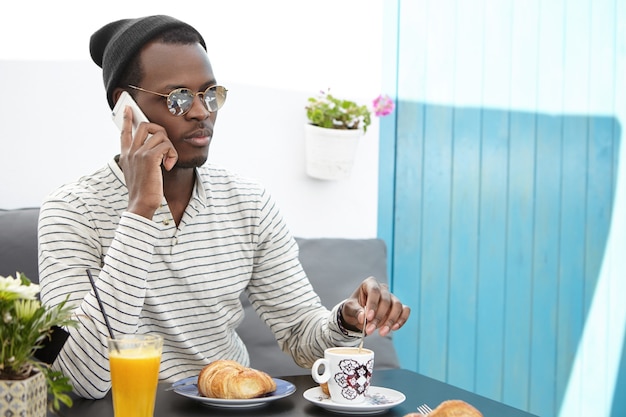 Elegante uomo afro-americano che si siede nella caffetteria