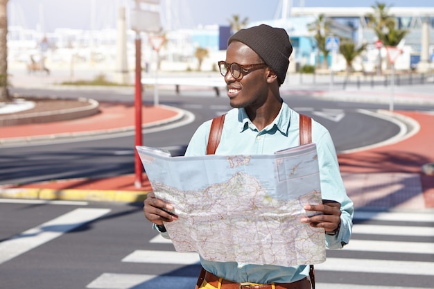 Stylish African-American man on street with map