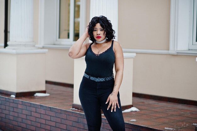 Stylish african american plus size model at streets of city on winter day