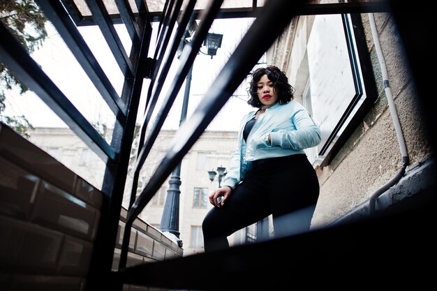 Stylish african american plus size model at streets of city on winter day