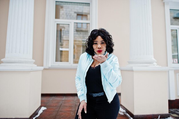 Stylish african american plus size model at streets of city on winter day